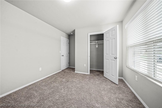 unfurnished bedroom with baseboards, carpet flooring, and a closet