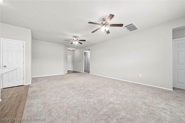 unfurnished bedroom with carpet flooring, a ceiling fan, baseboards, and visible vents