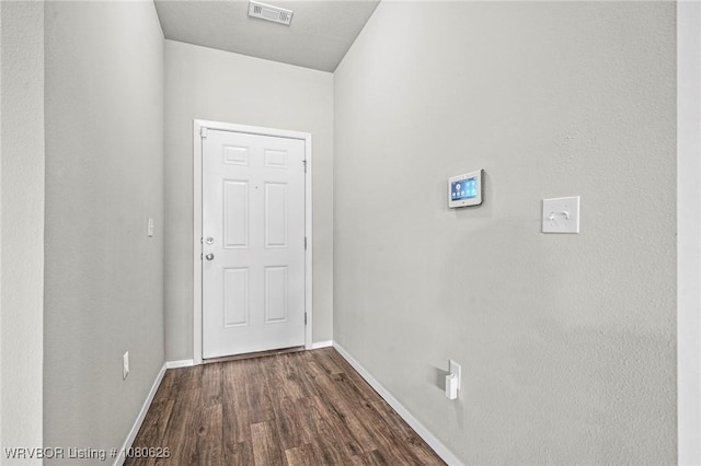 doorway to outside with baseboards, dark wood-type flooring, and visible vents