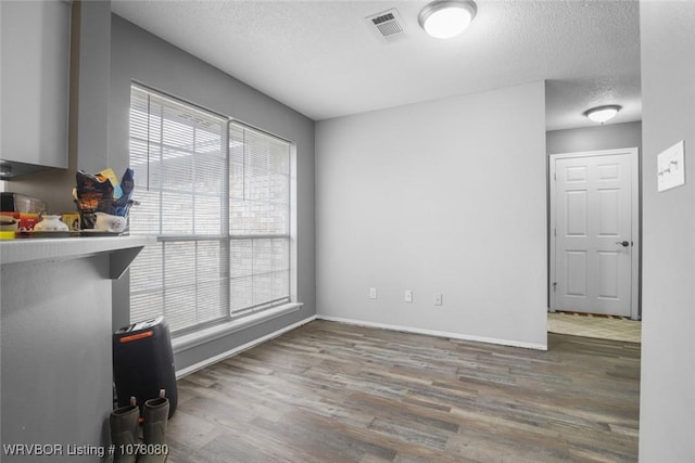 unfurnished room with dark hardwood / wood-style floors and a textured ceiling