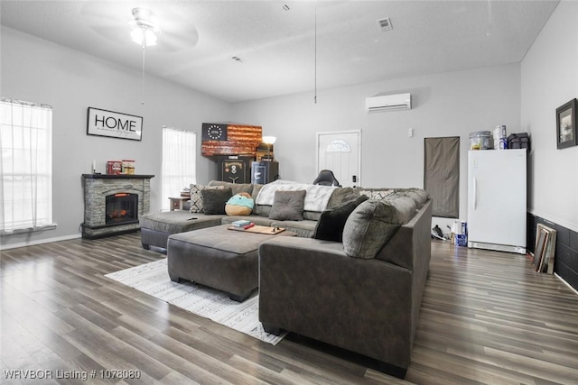 living room with an AC wall unit, ceiling fan, and dark wood-type flooring