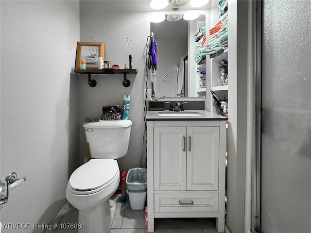 bathroom featuring tile patterned flooring, vanity, toilet, and a shower