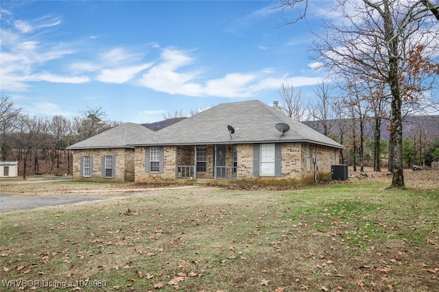 ranch-style house featuring central AC unit and a front lawn