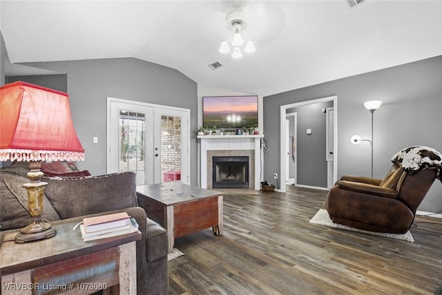 living room with lofted ceiling, a tile fireplace, french doors, dark hardwood / wood-style floors, and ceiling fan