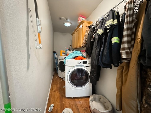 laundry area with cabinets, separate washer and dryer, and light hardwood / wood-style flooring