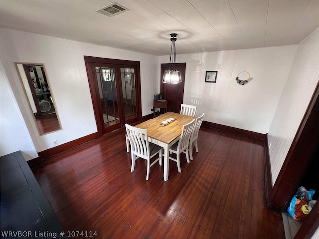 dining area with dark hardwood / wood-style floors and an inviting chandelier