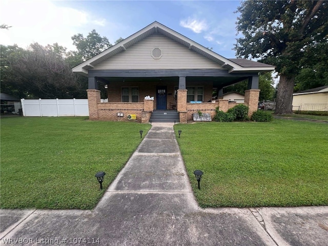 view of front facade with a front yard and covered porch