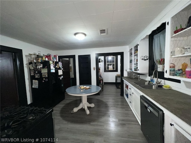 kitchen with dark wood-type flooring, black appliances, sink, built in features, and white cabinetry