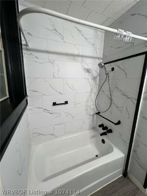 bathroom featuring wood-type flooring and tiled shower / bath combo