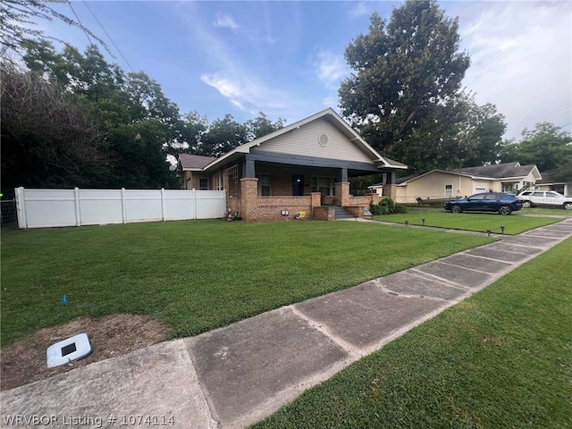 bungalow-style home with covered porch and a front lawn