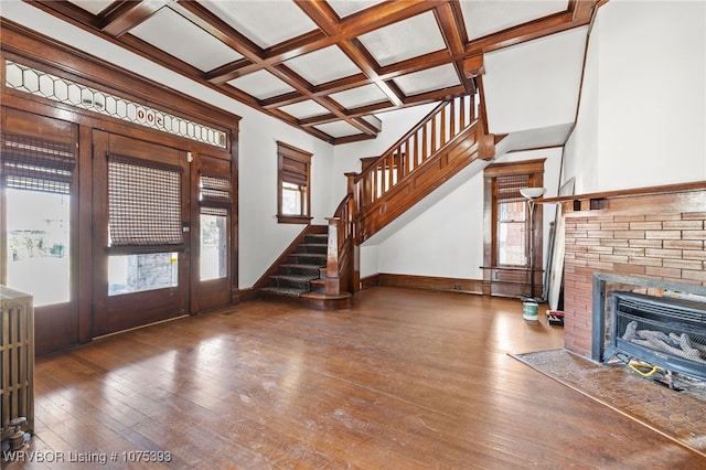 foyer featuring hardwood / wood-style floors, radiator, coffered ceiling, a fireplace, and beam ceiling