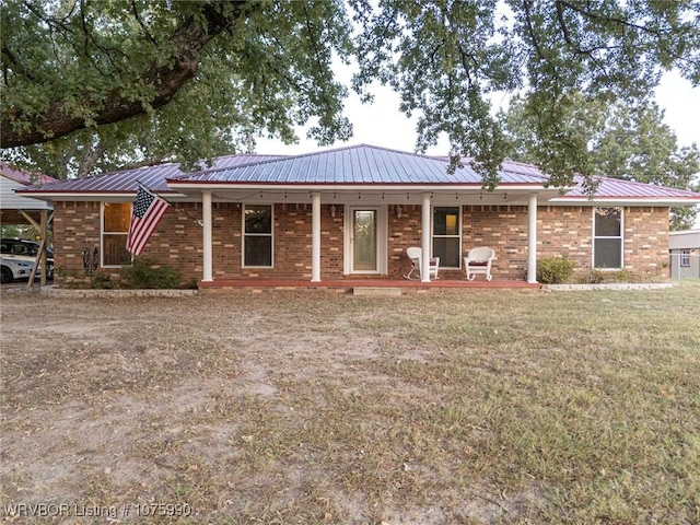 ranch-style home featuring a carport, a porch, and a front lawn