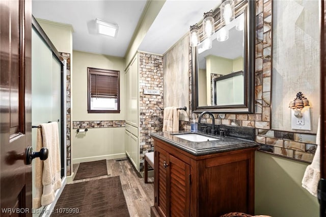 bathroom with hardwood / wood-style flooring, vanity, and ornamental molding