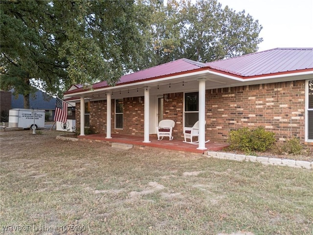 rear view of property with a porch and a yard