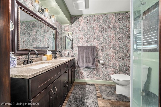 bathroom with hardwood / wood-style flooring, vanity, toilet, and a shower with door