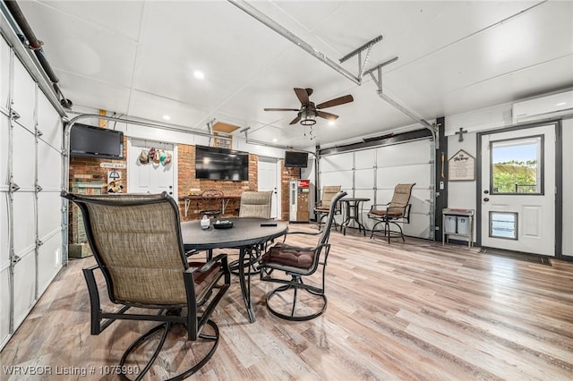 dining room featuring light hardwood / wood-style flooring, an AC wall unit, and ceiling fan