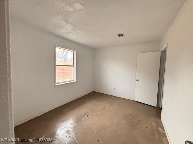 empty room featuring concrete flooring and a textured ceiling