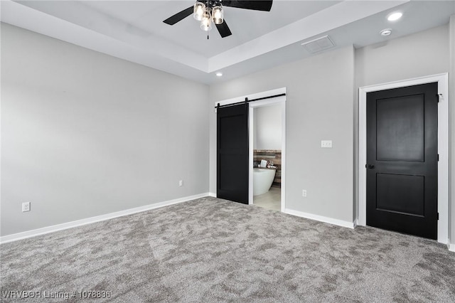 2006 Yellowstone Dr, Barling, AR 72923 - unfurnished bedroom featuring connected bathroom, carpet flooring, a raised ceiling, ceiling fan, and a barn door