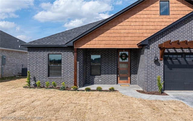 view of front of home featuring a garage and central air condition unit