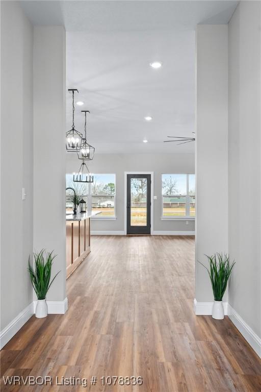 2006 Yellowstone Dr, Barling, AR 72923 - hallway with wood-type flooring, a wealth of natural light, and a chandelier