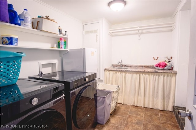 laundry room featuring washer and dryer, ornamental molding, and sink