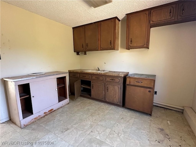 kitchen featuring a textured ceiling and sink