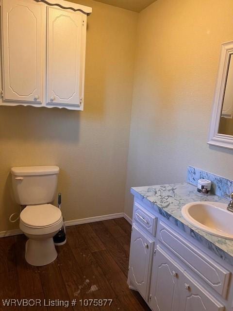 bathroom with vanity, wood-type flooring, and toilet