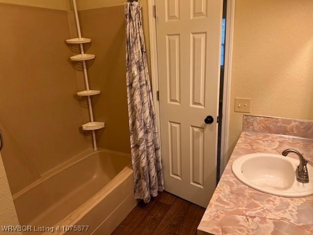 bathroom featuring hardwood / wood-style floors, vanity, and shower / tub combo