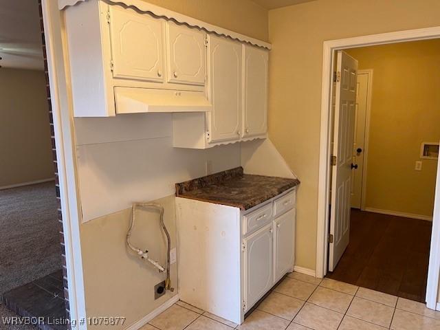 kitchen with white cabinets and light tile patterned floors