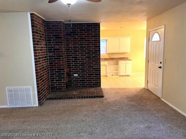 unfurnished living room featuring carpet and ceiling fan