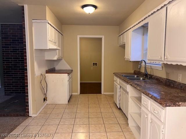 kitchen featuring sink, white cabinetry, and light tile patterned flooring