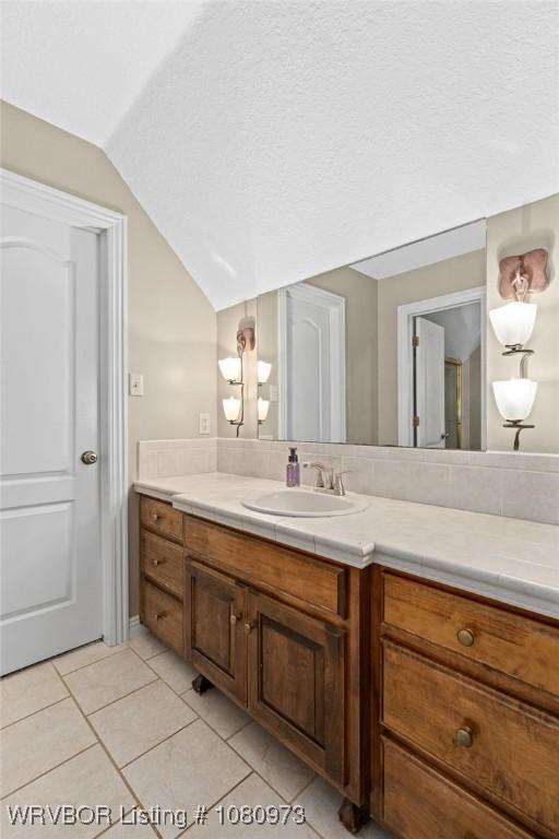 6800 Highland Park Dr, Fort Smith, AR 72916 - bathroom featuring lofted ceiling, vanity, tile patterned floors, and a textured ceiling