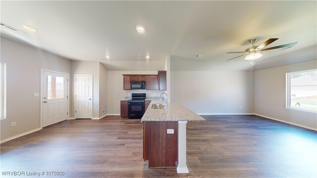 kitchen with light stone counters, ceiling fan, dark wood-type flooring, sink, and black appliances