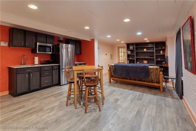 1232 Elizabeth Ln, Fort Smith, AR 72903 - kitchen with appliances with stainless steel finishes, light wood-type flooring, light countertops, ornamental molding, and recessed lighting