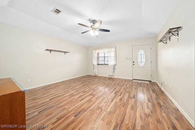 entrance foyer with lofted ceiling, hardwood / wood-style floors, a textured ceiling, and ceiling fan