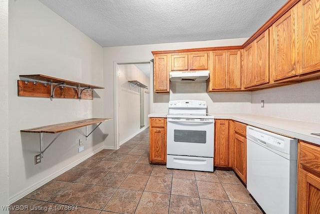 kitchen featuring tile patterned flooring, white appliances, and a textured ceiling