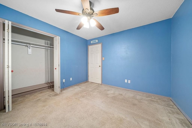 unfurnished bedroom featuring ceiling fan, light colored carpet, and a closet