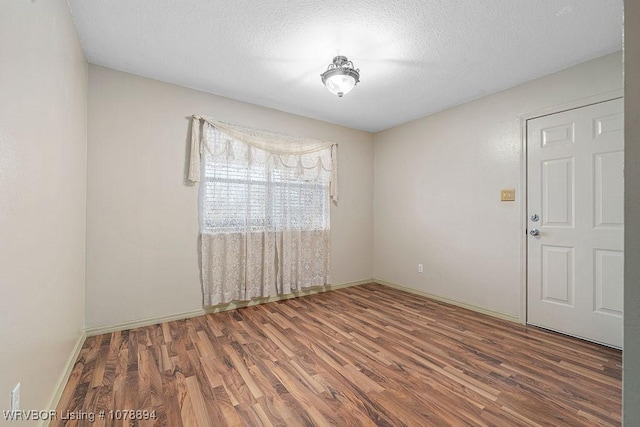 spare room featuring hardwood / wood-style flooring and a textured ceiling