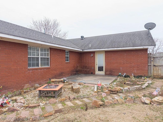 rear view of house featuring a fire pit and a patio