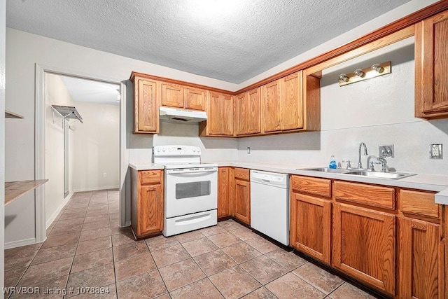 kitchen with white appliances, sink, a textured ceiling, and light tile patterned floors