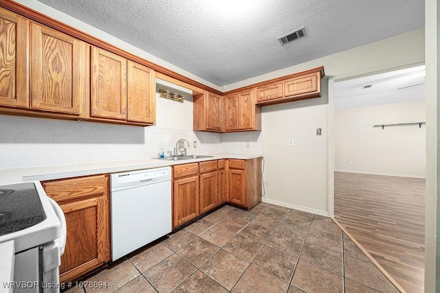 kitchen featuring sink, white appliances, and a textured ceiling