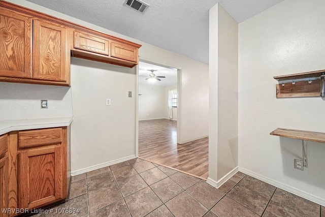 kitchen featuring a textured ceiling, tile patterned floors, and ceiling fan