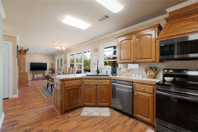 7441 Valley Creek Rd, Cecil, AR 72930 - kitchen featuring light wood finished floors, stainless steel appliances, light countertops, visible vents, and crown molding