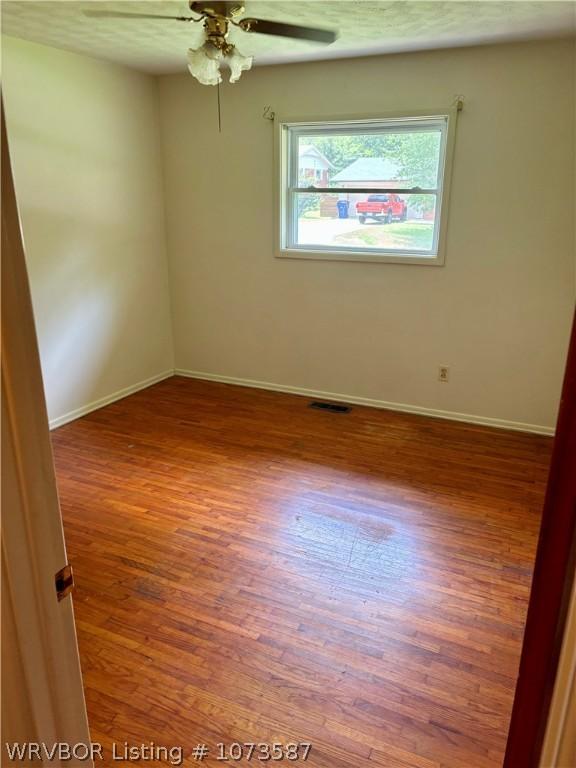 unfurnished room featuring ceiling fan and wood-type flooring