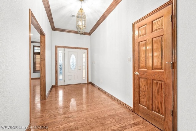 entrance foyer with light hardwood / wood-style flooring and crown molding