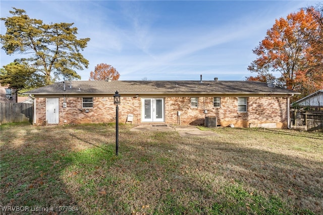 back of property with a lawn, cooling unit, and french doors