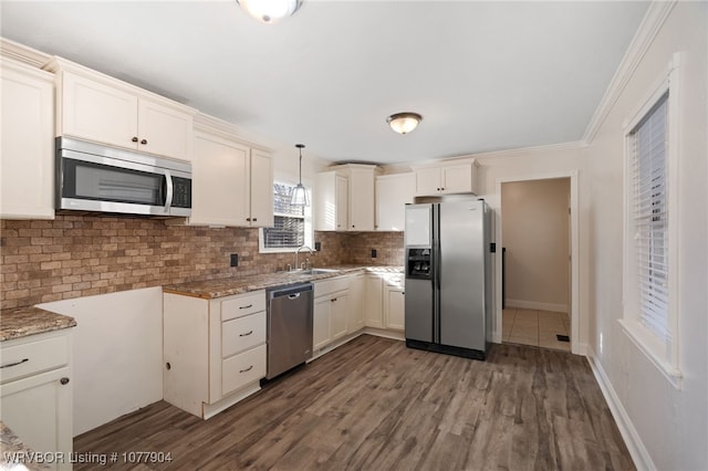 kitchen featuring light stone countertops, dark wood-type flooring, stainless steel appliances, decorative light fixtures, and decorative backsplash