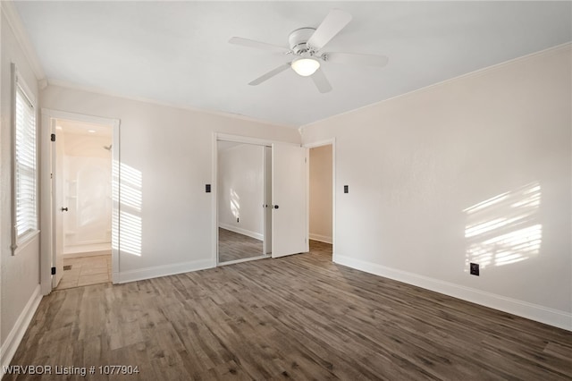 unfurnished bedroom with ceiling fan, a closet, dark hardwood / wood-style flooring, and ensuite bath