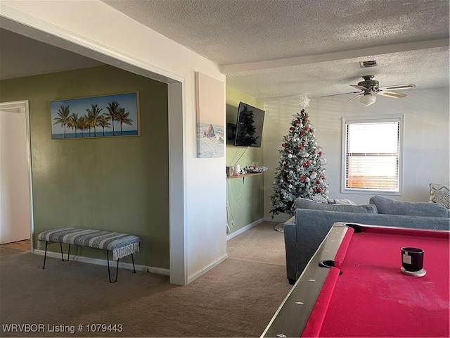 recreation room featuring a textured ceiling, carpet floors, a ceiling fan, and baseboards