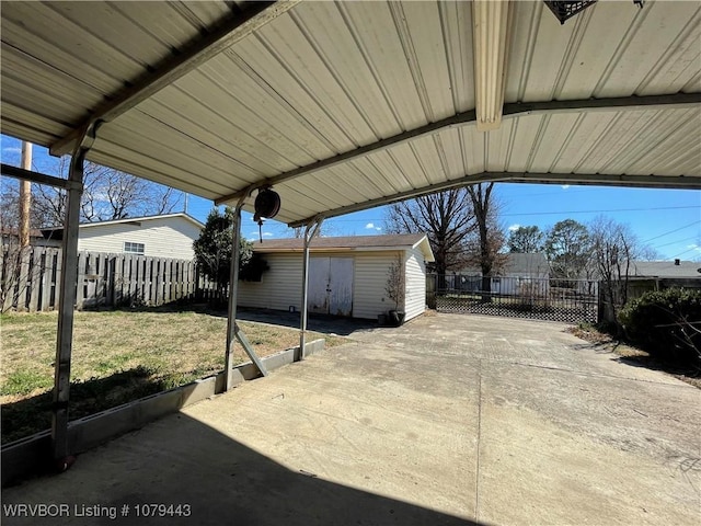 view of patio / terrace with fence, a carport, and an outdoor structure